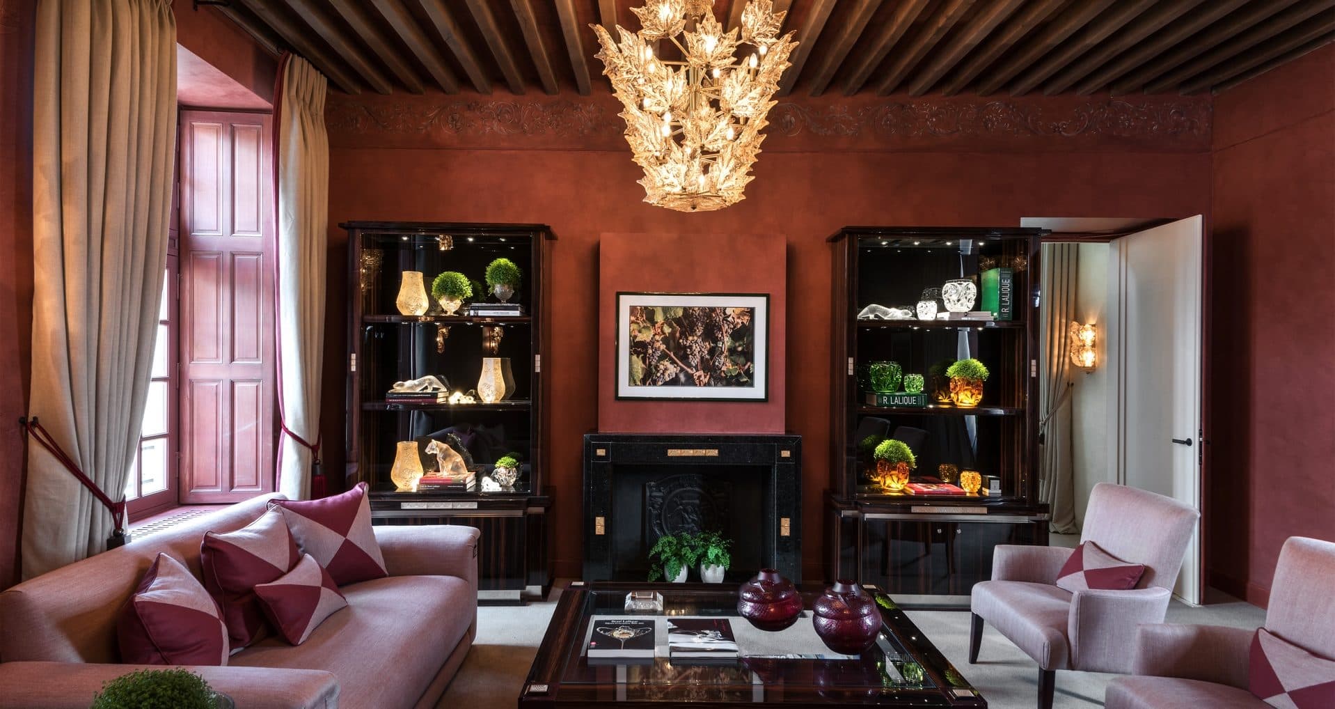The library and bar, tall shelves of bound volumes, low lamps and a fire laid by armchairs.