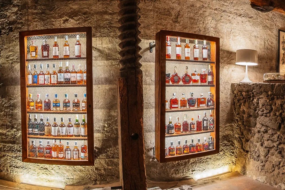 The Acqua Vitae liquor room, low light on bottles drawn from the estate's own cellar.