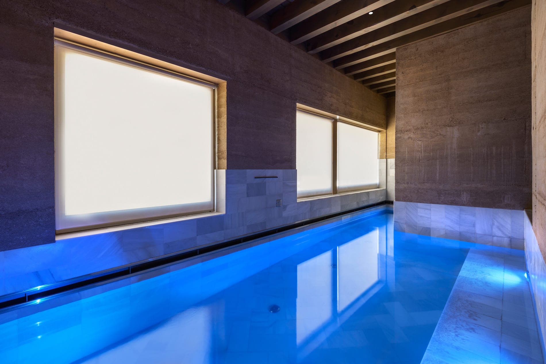 The spa at Torre del Marqués, an indoor pool held in pale stone under low light.